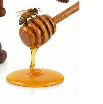 Wooden honey dipper drizzling golden honey